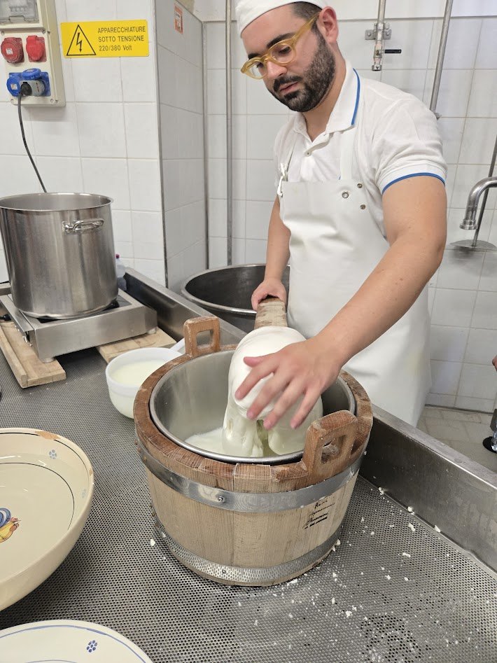 A pugliese dairyman pulling a fresh burrata, the white curd stretched between his hands — a private demonstration arranged for Casa Andrea guests.