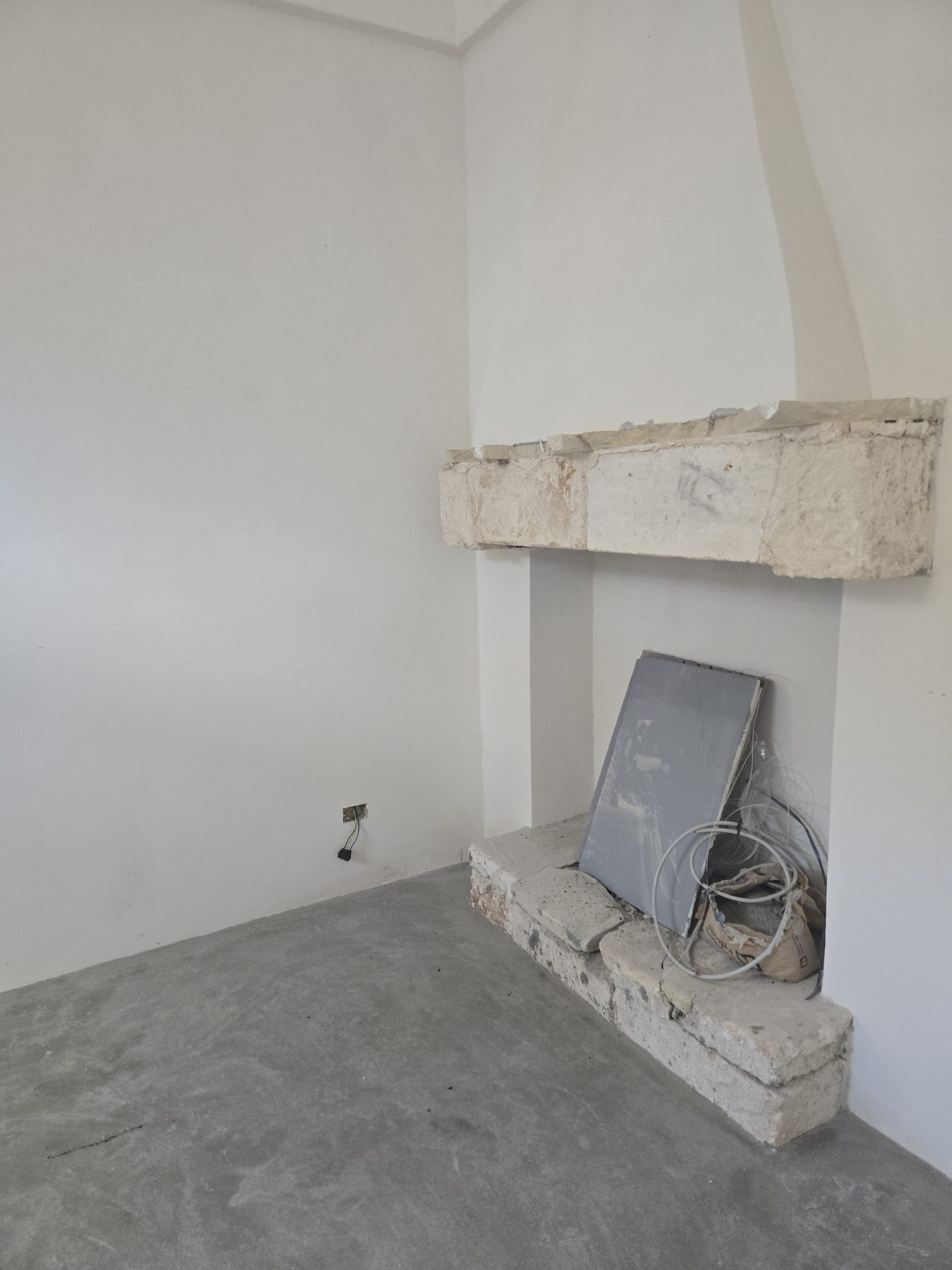 Niches d'étagères creusées dans le mur chaulé d'une chambre de Casa Andrea, dans la tradition des Pouilles, août 2025.