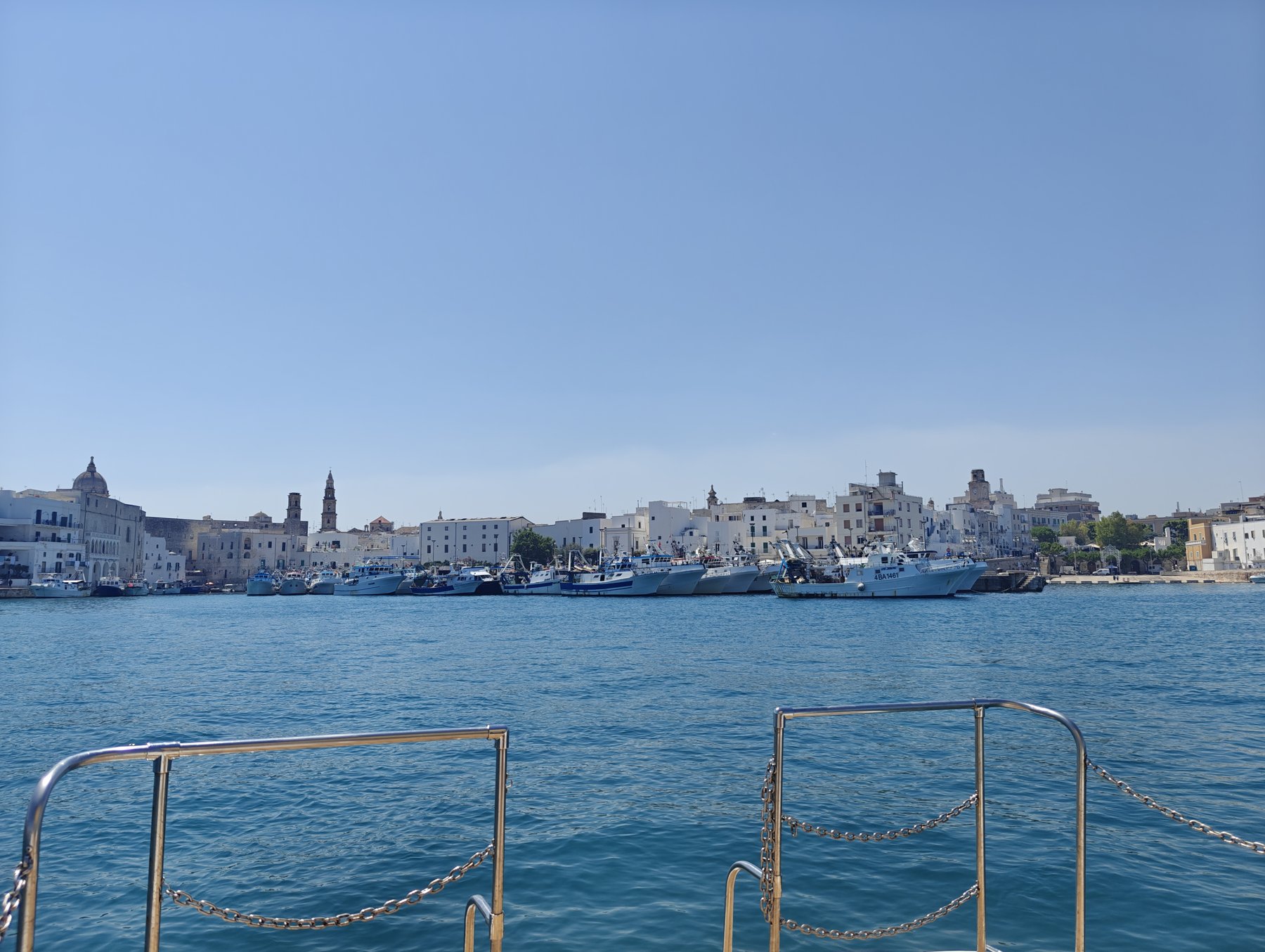 The harbour of Monopoli near Casa Andrea, fishing boats on clear water, Puglia.